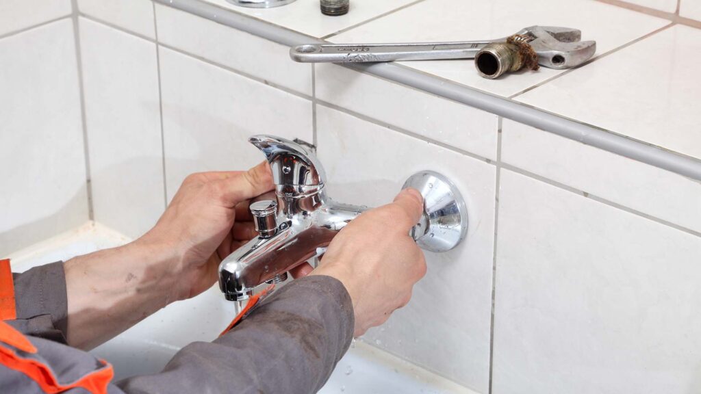 Technicien intervenant sur un système de plomberie